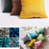 A collection of velvet cushion covers in shades of olive green, mustard yellow, and deep brown.