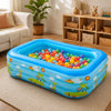 A bright blue inflatable pool filled with colorful plastic balls, resting on a light-colored rug.