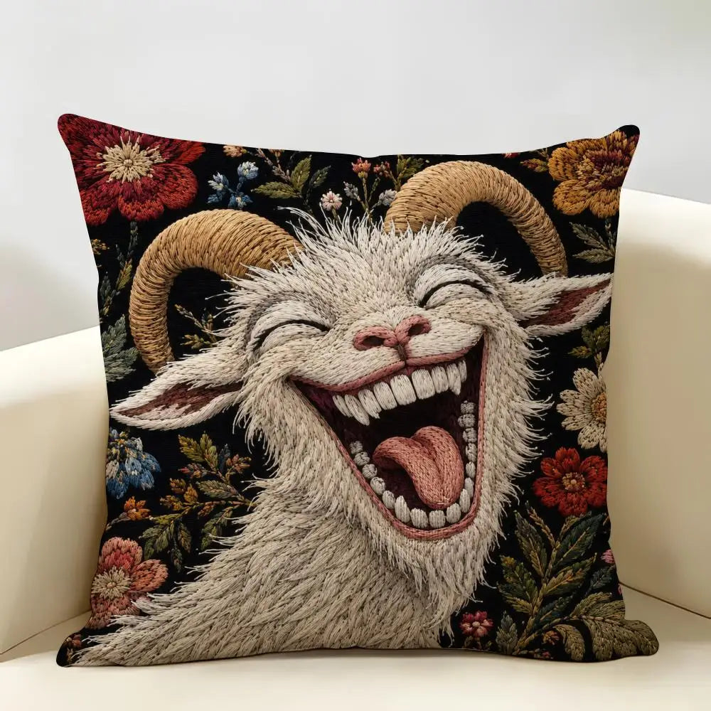 A knitted goat face with horns and an open mouth laughing or screaming, displayed on a dark floral cushion cover.