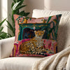 A decorative cushion cover featuring a leopard print cheetah design surrounded by lush green foliage and floral accents.