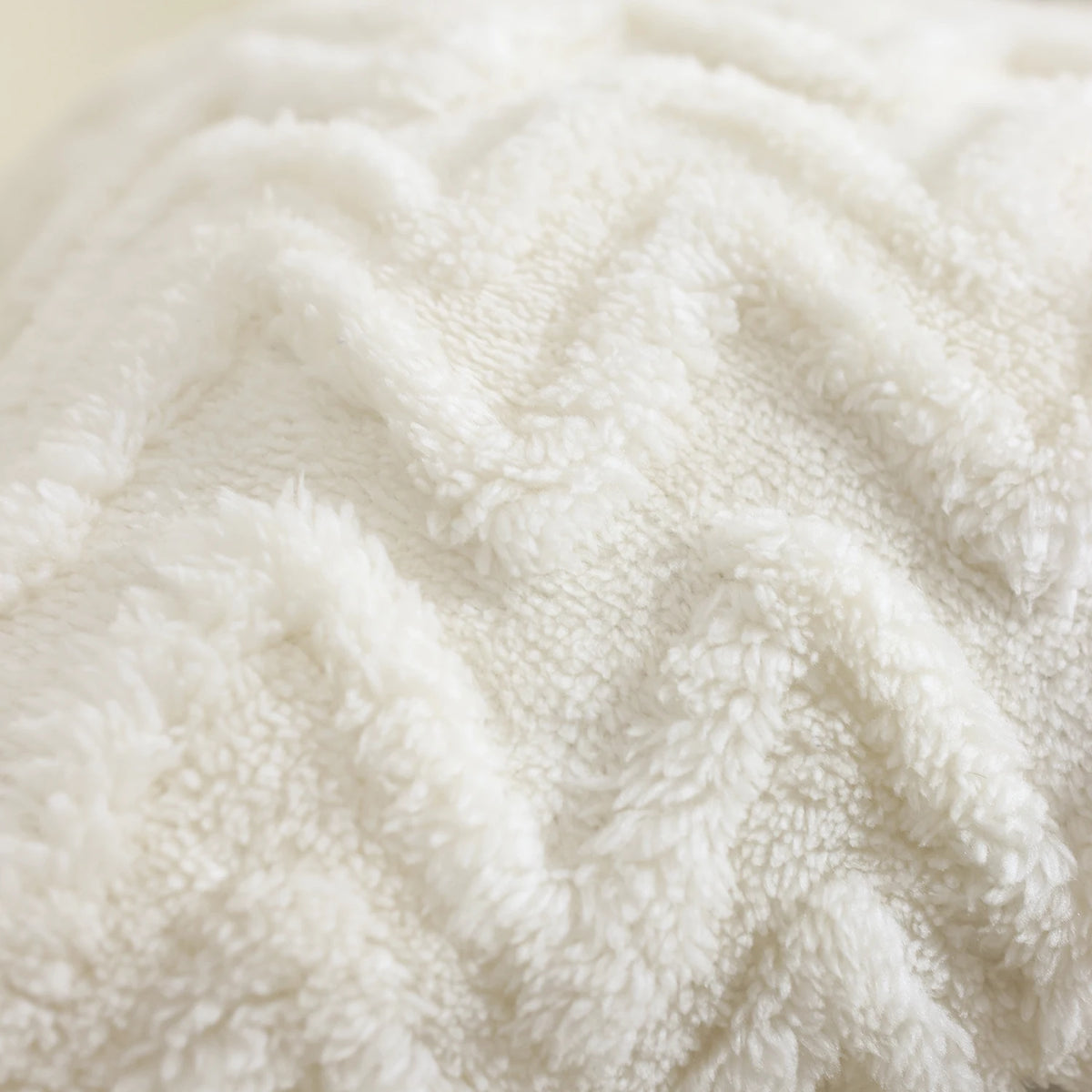 Close-up of a white jacquard plush throw pillow cover with a geometric textured pattern.