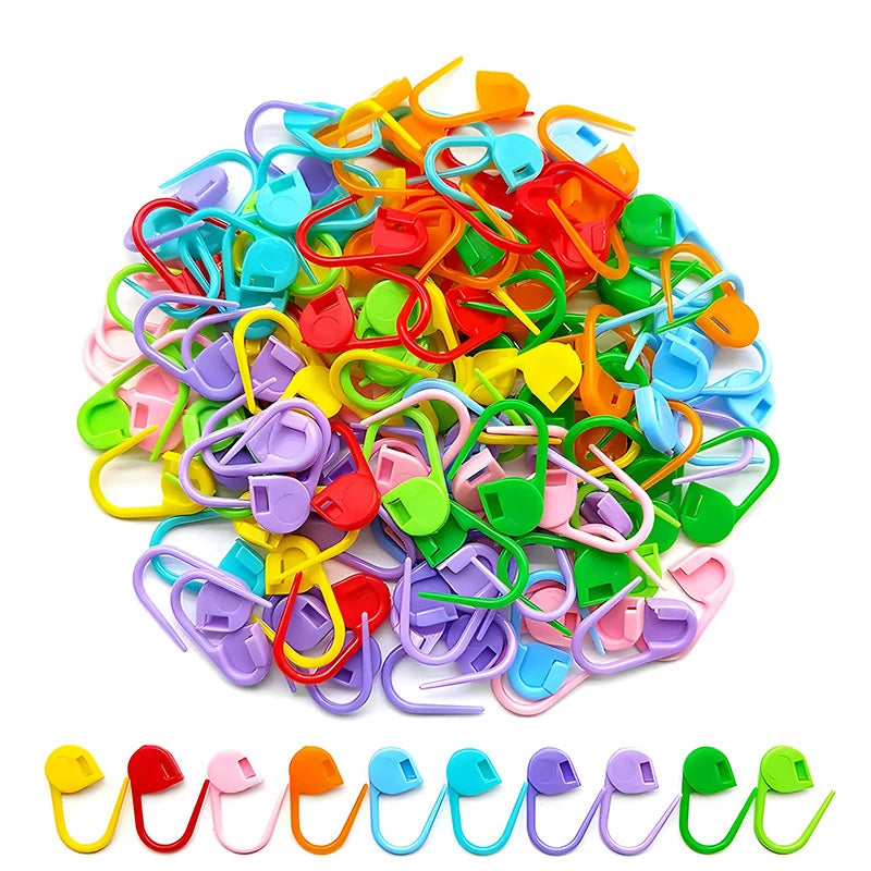 A pile of colorful stitch markers in various shapes and colors for knitting and crochet projects