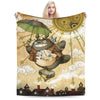 A fleece throw blanket featuring a Totoro character design with large eyes and a green umbrella against a light background.