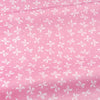 Pink cotton twill fabric with a white floral and stripe pattern for sewing and DIY projects