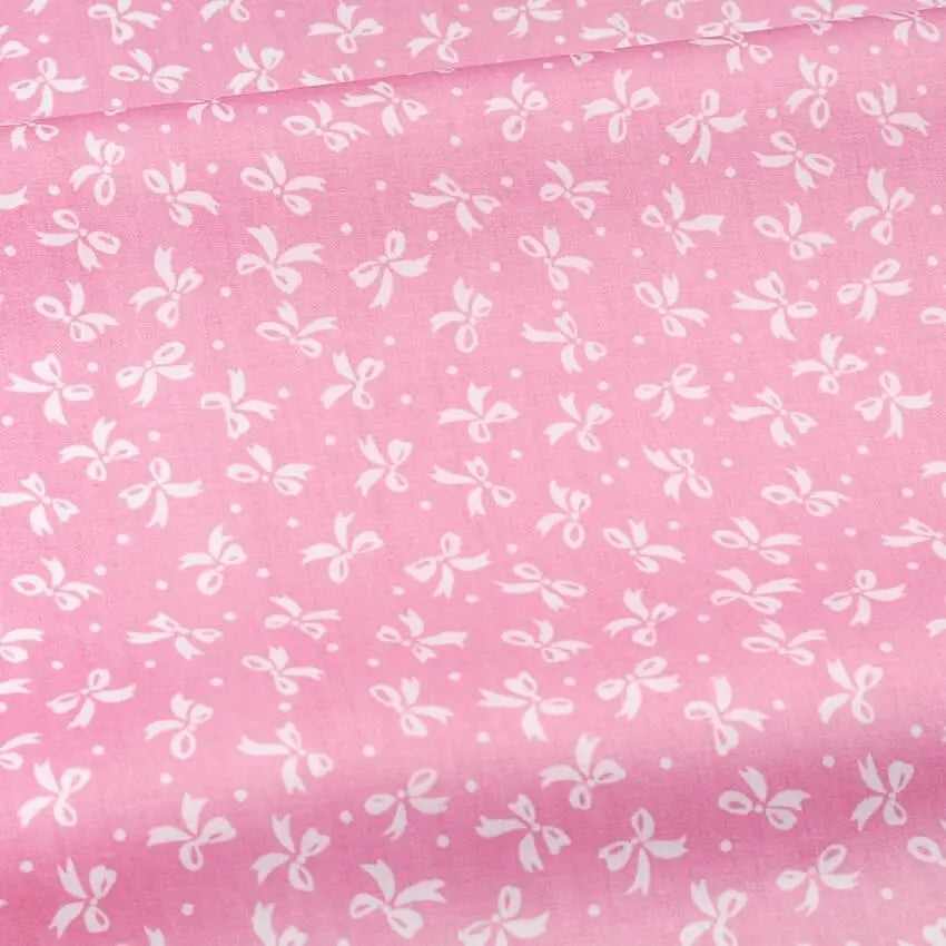 Pink cotton twill fabric with a white floral and stripe pattern for sewing and DIY projects