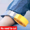 Yellow no-sew hem tape with a white and gray striped edge being applied to denim fabric.