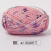 Pink hand-dyed fabric strip yarn with purple and green floral patterns, coiled for crochet or knitting.