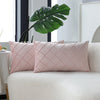 Two pink quilted velvet decorative pillow covers resting on a white sofa.