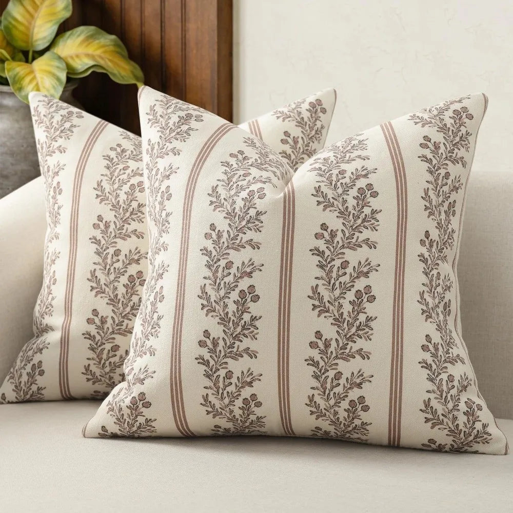 A close-up of a vintage striped floral throw pillow cover with muted olive green and beige tones.