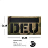A dark olive camouflage patch with the text IDEU embroidered on it, featuring a hook and loop backing.