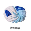 A ball of hand-woven chunky chenille yarn featuring white, light blue, and deep blue colors.