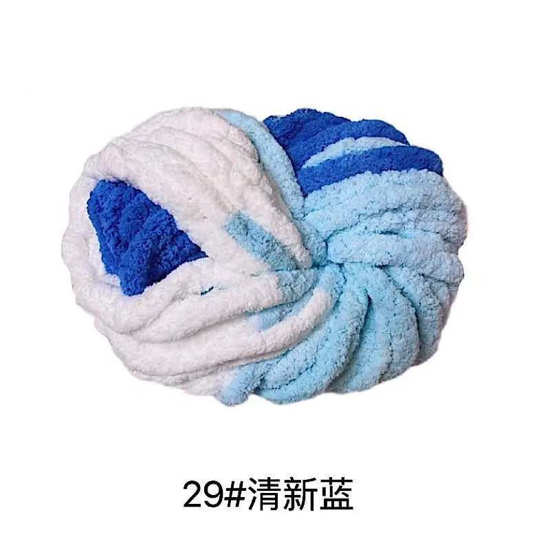 A ball of hand-woven chunky chenille yarn featuring white, light blue, and deep blue colors.
