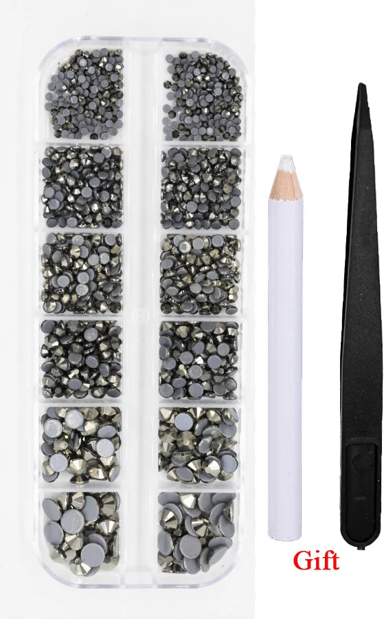 A clear plastic case containing various sizes and colors of crystal hot fix rhinestones and an applicator tool.