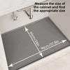 A silicone cabinet liner mat is shown being measured for proper sizing inside a kitchen cabinet.