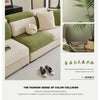 A close-up of a green patterned jacquard sofa cover with cream cushions and pillows.