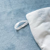 A white cozy rabbit fleece duvet cover with a white drawstring is displayed on a blue textured fabric.