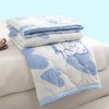 A stack of light blue and white quilted blankets featuring a cute bear design on a white background.