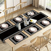 A set of luxury geometric placemats and a table runner displayed on a wooden dining table with place settings.