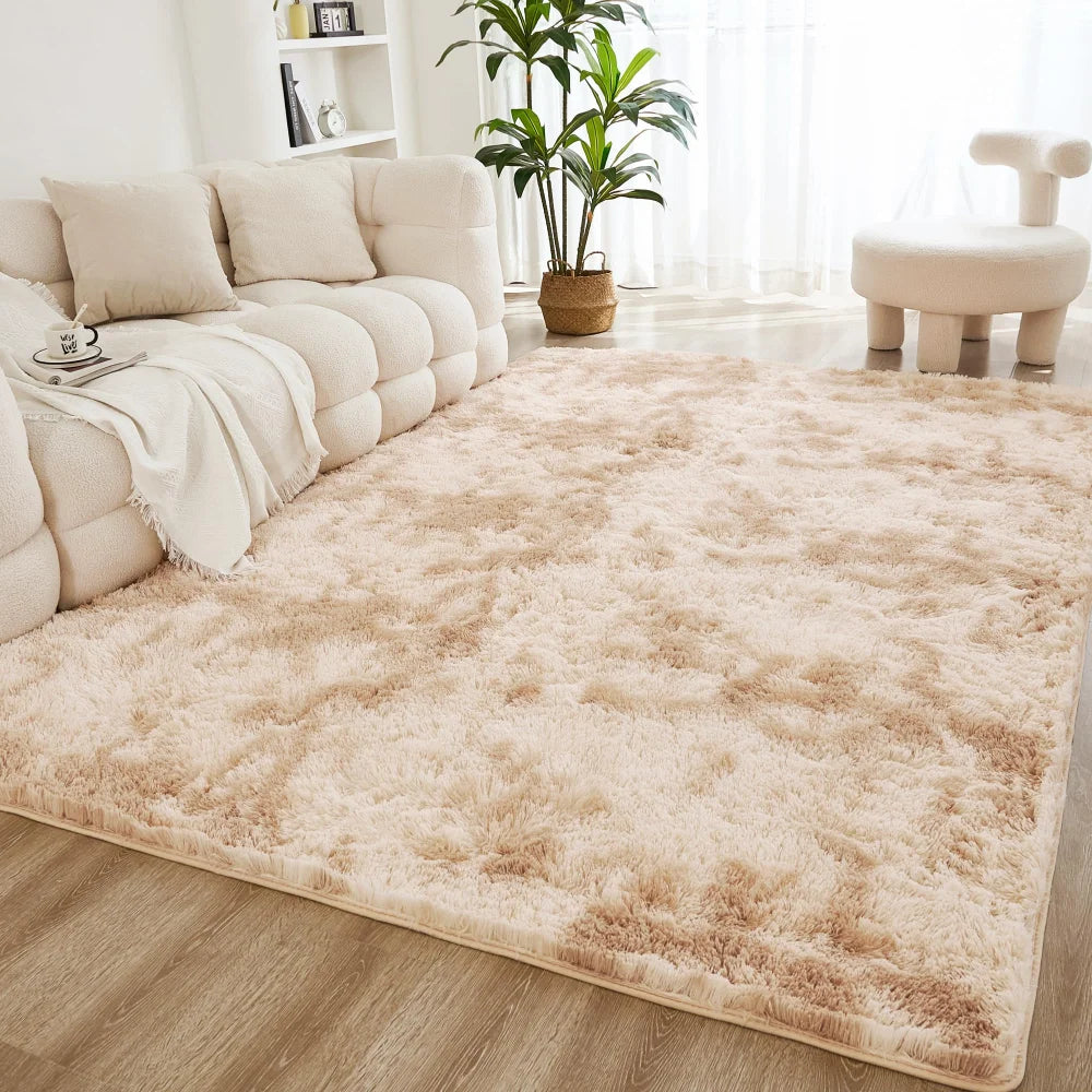 A fluffy cream tie-dye shaggy rug placed on a light wood floor in a bright living room setting.