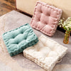 Three quilted cotton throw pillows in pink, mint green, and cream resting on a beige rug.