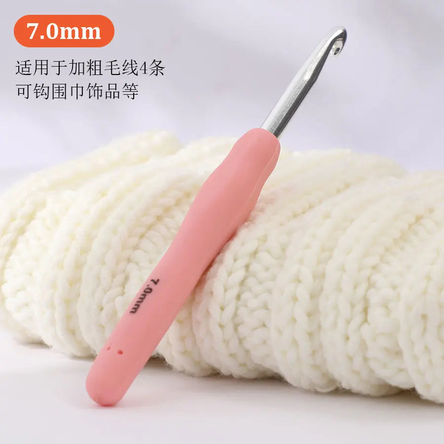 A pink precision aluminum crochet hook is shown next to a ball of white yarn.