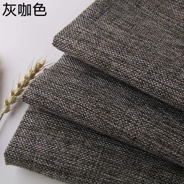 Close-up of dark gray coarse linen and cotton fabric rolled up, showing the texture.