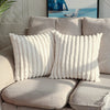 A close-up of a white stripe corduroy pillow cover resting on a beige sofa.