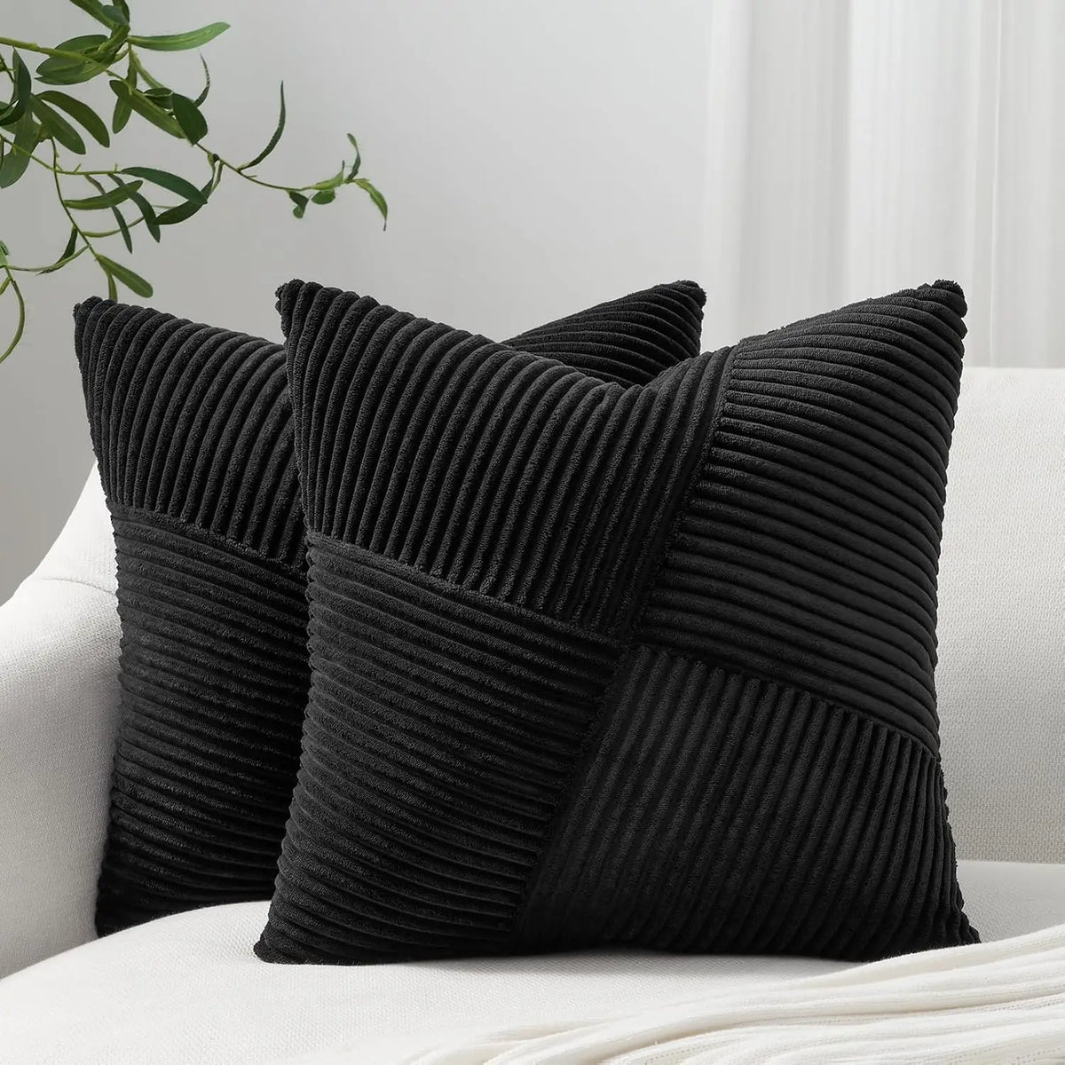 A black textured corduroy throw pillow cover is shown on a white surface.
