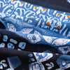 Close-up of blue and white bohemian printed linen fabric folds showing intricate patterns.