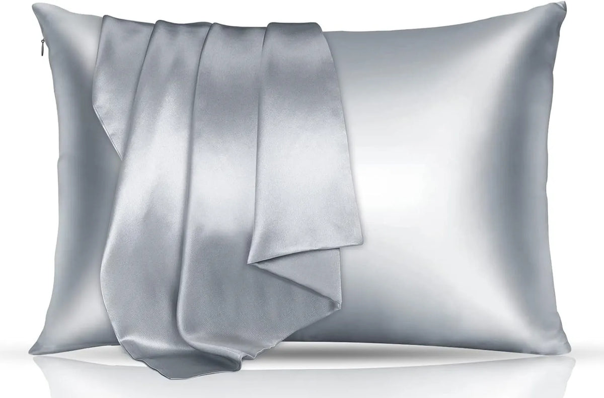 A silver silky satin toddler pillowcase folded and displayed on a reflective surface.