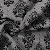 Damascus pattern fabric with black floral and damask motifs on a gray background.
