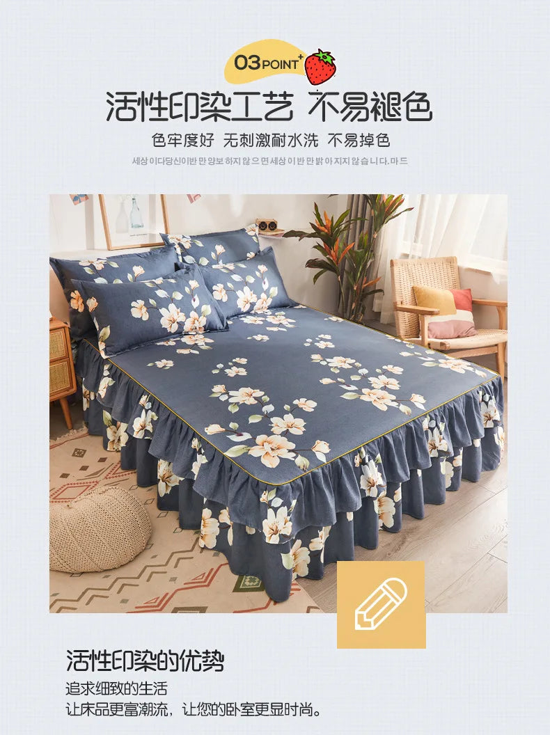 A navy blue bed skirt with a white floral print is displayed on a bed, featuring ruffled edges.