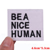 White embroidered patch with black text reading BE A NICE HUMAN