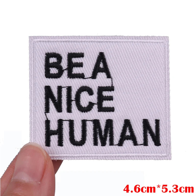 White embroidered patch with black text reading BE A NICE HUMAN