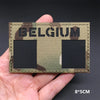 A close-up of a rectangular tactical patch featuring the word BELGIUM in large letters on a camouflage background.