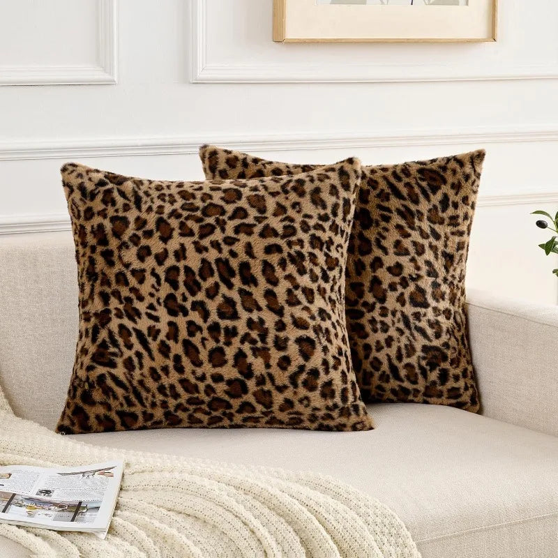Two brown leopard print velvet pillow covers resting on a light-colored sofa.
