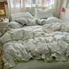 A floral bedding set featuring light green and white patterned fabric on a bed.
