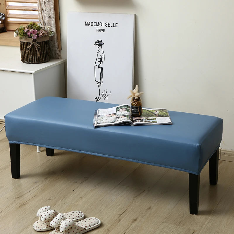 A blue dining bench cover is displayed on a wooden bench, with a framed piece of art in the background.