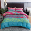 A vibrant boho geometric duvet cover set featuring teal, pink, and yellow floral patterns on a bed.