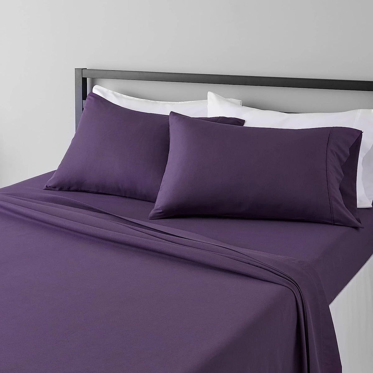 A purple microfiber flat fitted sheet set with white pillows on a bed.