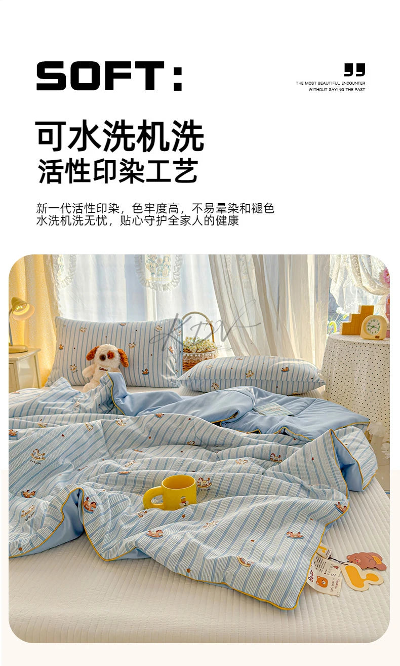 A light blue and white cartoon patterned quilt is displayed on a bed, featuring small animal designs.
