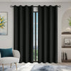 Solid black blackout window curtains with grommets hanging in a doorway.