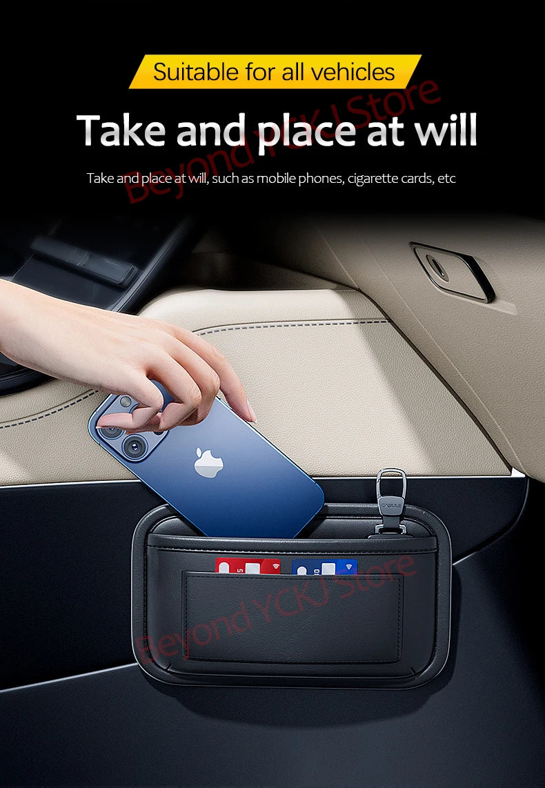 A hand places an Apple phone into a black universal car organizer storage bag inside a car interior.