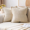 A beige striped corduroy lumbar support pillow cushion resting on a light-colored sofa.