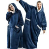 A man and a woman wearing matching navy blue velvet oversized flannel blanket pyjama sets.