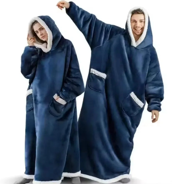 A man and a woman wearing matching navy blue velvet oversized flannel blanket pyjama sets.