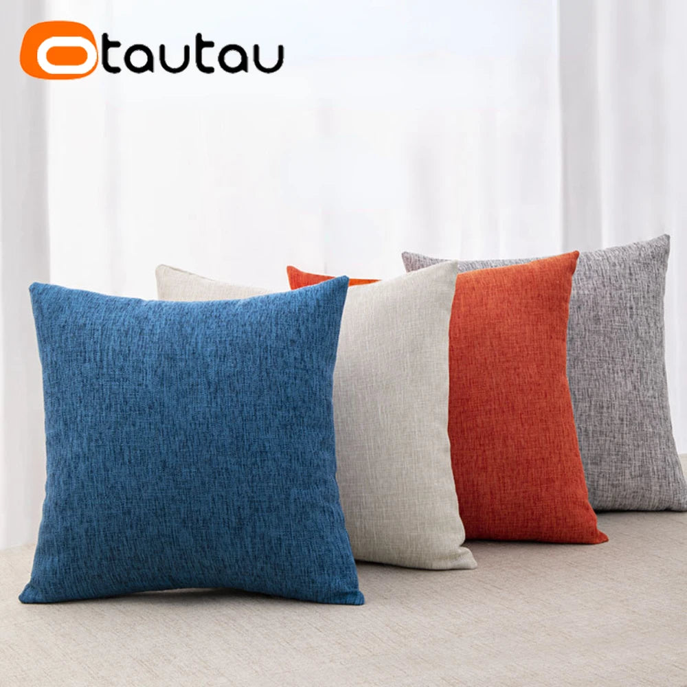 A collection of square linen cushions in shades of blue, orange, and gray displayed on a light surface.