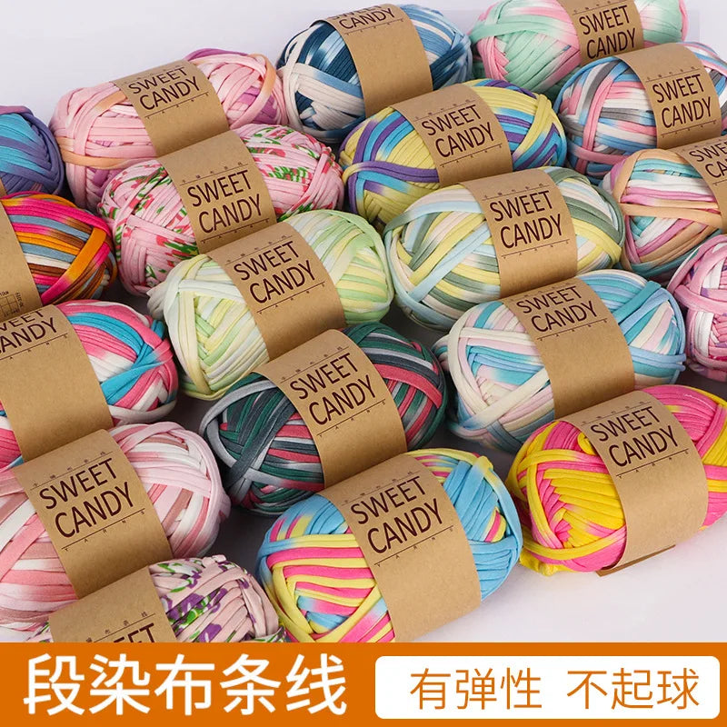 Assortment of hand-dyed fabric strip yarn in various colors and shades packaged for crochet and knitting