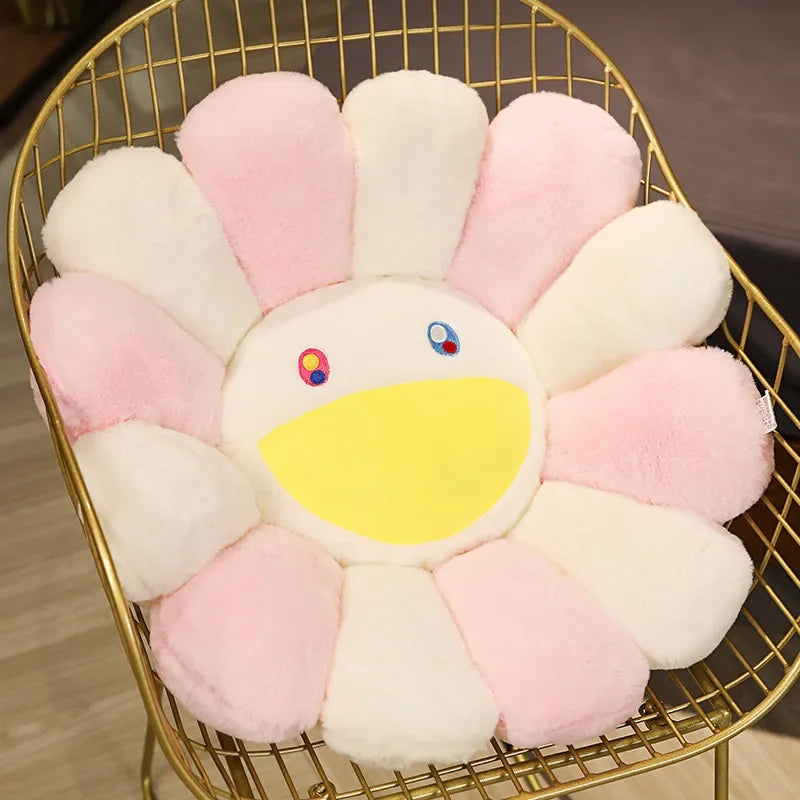 A cozy sunflower plush cushion with a smile face made of pink and white faux fur, displayed in a gold wire basket.