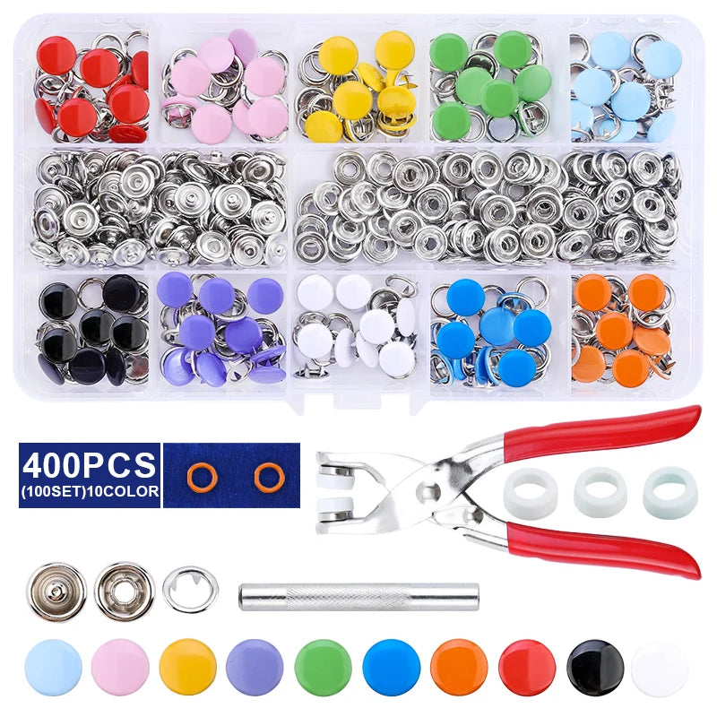 A collection of heavy duty metal snap fasteners in various colors and sizes, including a pair of pliers and assorted rings.